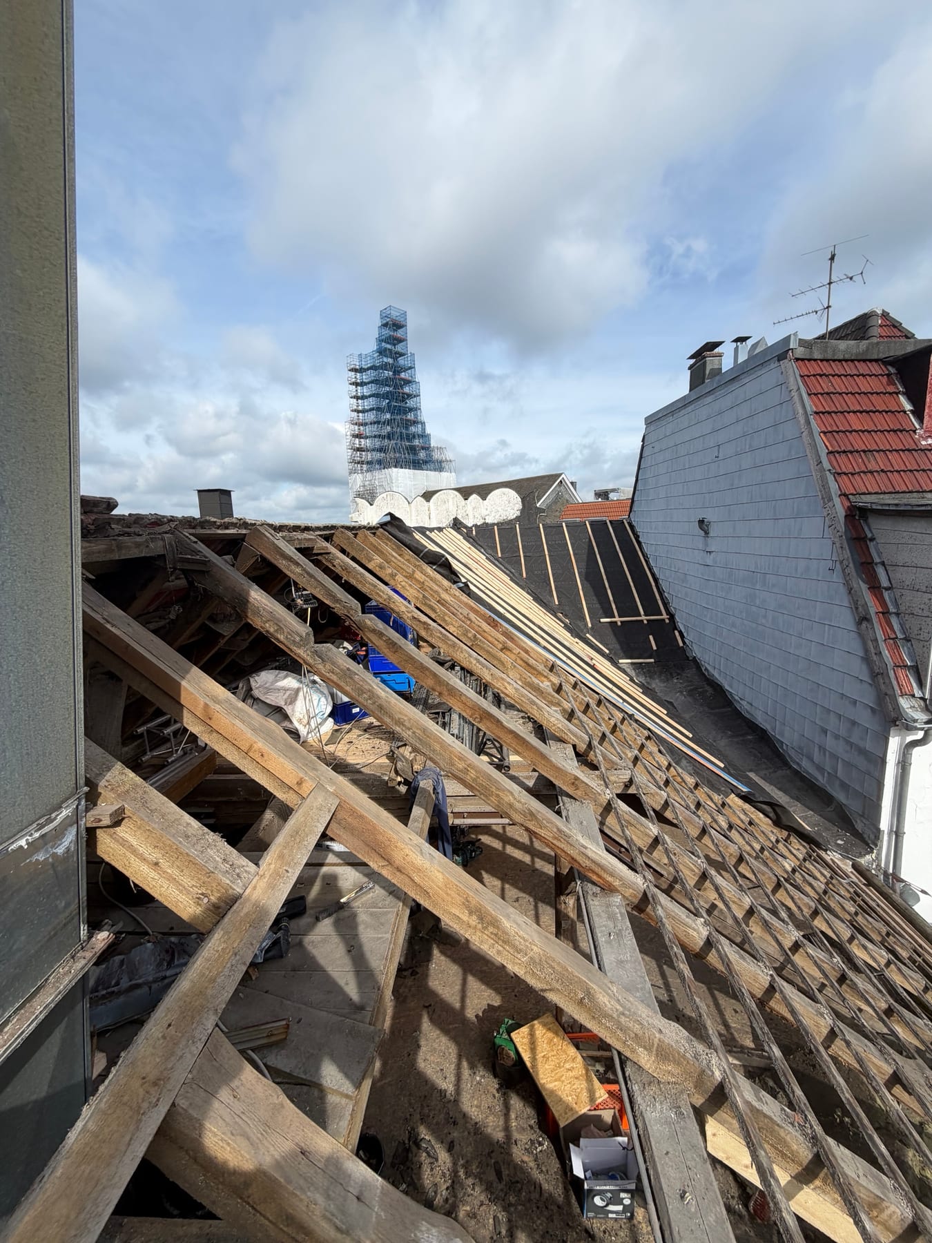 Das offene Dach des Capitol mit freigelegtem Gebälk, im Hintergrund der eingerüstete Kirchturm
